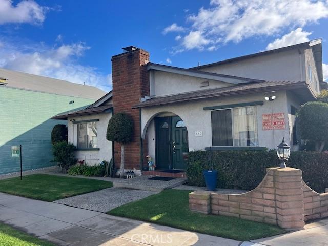 view of front of property featuring a chimney and stucco siding