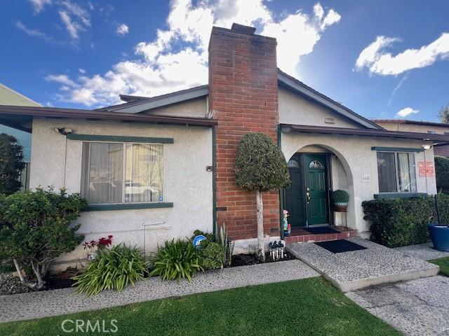 doorway to property featuring a chimney and stucco siding