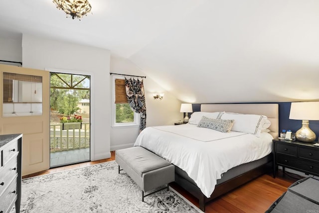 bedroom with access to exterior, wood finished floors, baseboards, and lofted ceiling