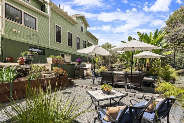 view of patio featuring grilling area, outdoor dining space, and fence