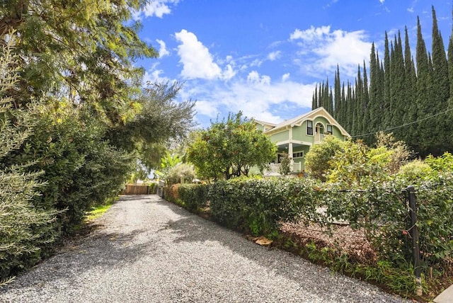 exterior space featuring gravel driveway and fence