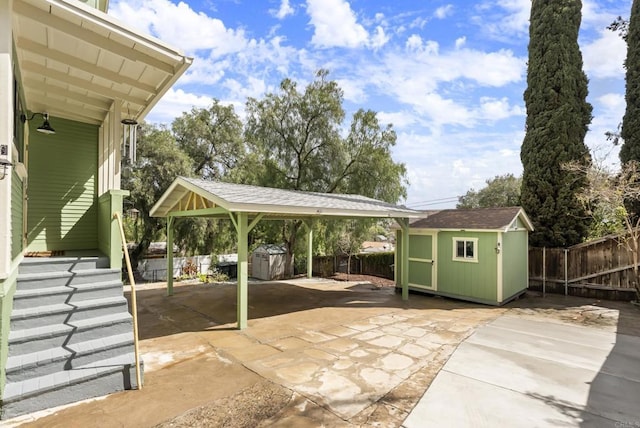 view of patio / terrace featuring an outdoor structure, a storage unit, and fence