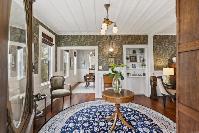 interior space featuring wainscoting, wallpapered walls, crown molding, and hardwood / wood-style flooring