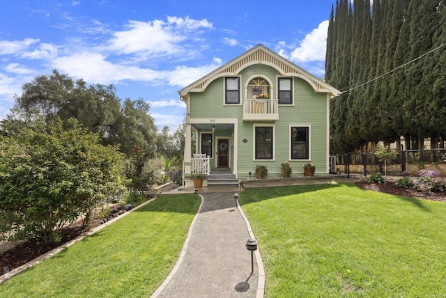 victorian-style house featuring a front lawn and fence