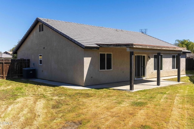 rear view of house with a yard, cooling unit, a patio, and fence