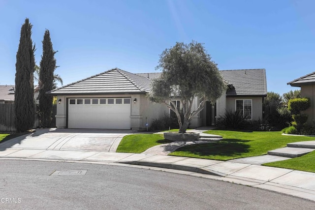 ranch-style house featuring a tile roof, driveway, an attached garage, and a front yard