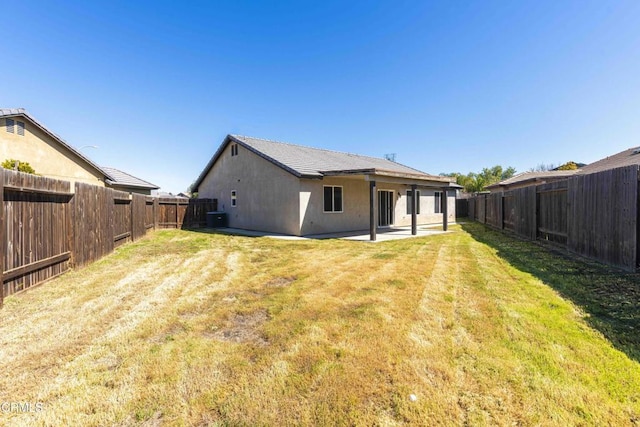 rear view of property with a patio area, a lawn, a fenced backyard, and stucco siding