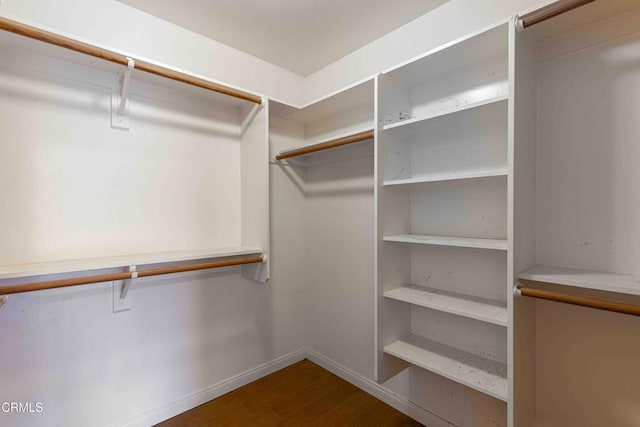 walk in closet with wood finished floors