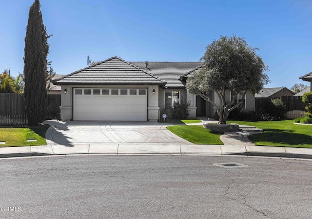 view of front facade featuring an attached garage, a front lawn, fence, a tiled roof, and driveway