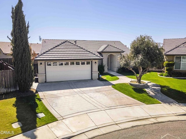 view of front of property featuring fence, a tile roof, concrete driveway, stucco siding, and an attached garage