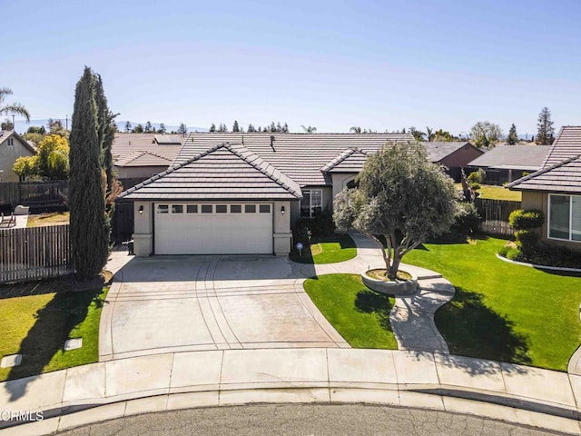 view of front of property with fence, driveway, a front lawn, a garage, and a tile roof