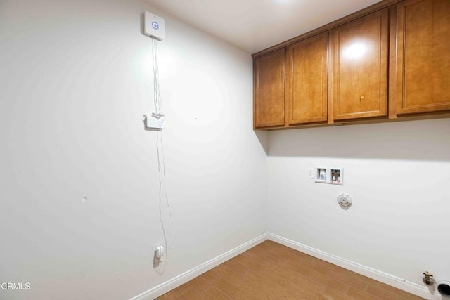 laundry area featuring hookup for a washing machine, baseboards, light wood finished floors, cabinet space, and hookup for a gas dryer