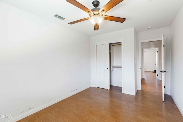 unfurnished bedroom with light wood-type flooring, visible vents, baseboards, and a closet