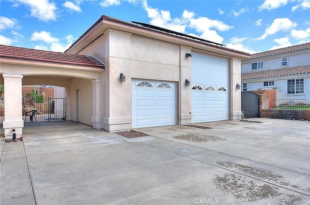 garage with a gate, driveway, and fence