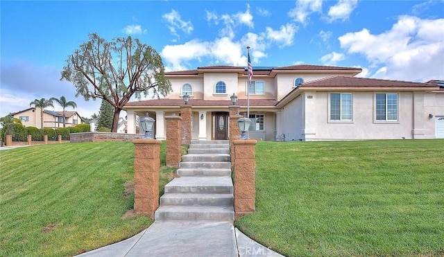 mediterranean / spanish home featuring stucco siding, roof mounted solar panels, and a front yard