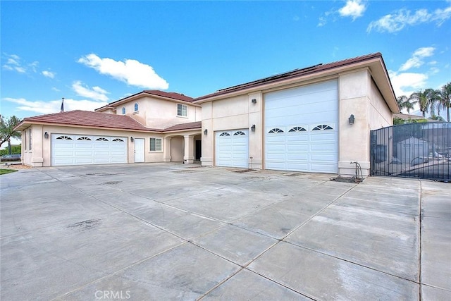 view of front of home with stucco siding, a garage, and driveway