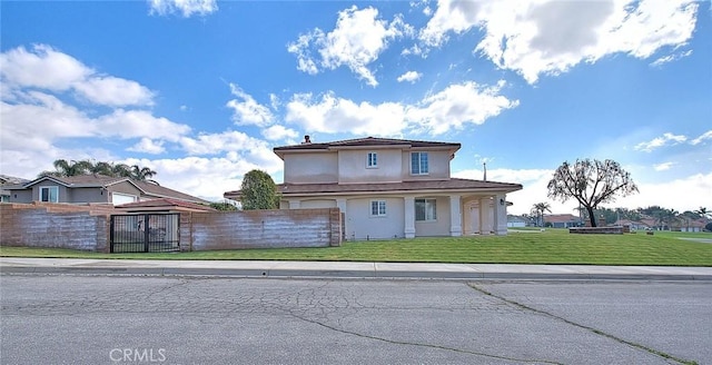 view of front of home featuring a fenced front yard, stucco siding, and a front lawn