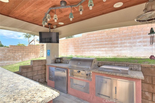 view of patio featuring exterior kitchen, area for grilling, and fence