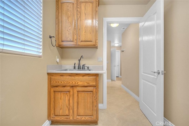 interior space featuring baseboards and a sink