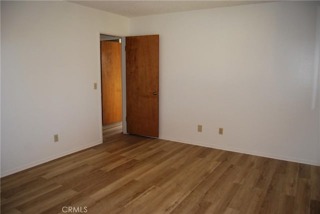 unfurnished room featuring baseboards and light wood finished floors