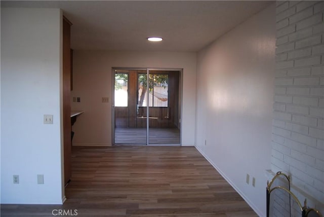 corridor with baseboards and wood finished floors