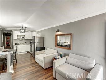 living area featuring lofted ceiling, dark wood finished floors, and crown molding