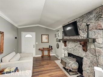 living area with ornamental molding, wood finished floors, a fireplace, baseboards, and vaulted ceiling