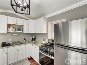 kitchen featuring vaulted ceiling, ornamental molding, appliances with stainless steel finishes, and a sink