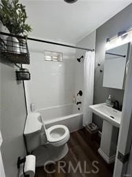 bathroom featuring shower / bath combination with curtain, toilet, and wood finished floors