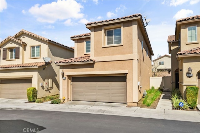 mediterranean / spanish house featuring stucco siding, a garage, and fence