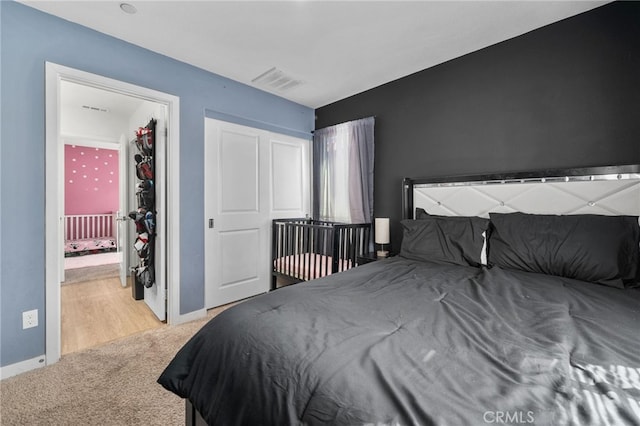 bedroom with visible vents, carpet flooring, connected bathroom, and baseboards