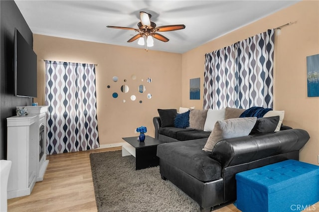 living room featuring light wood-type flooring and ceiling fan