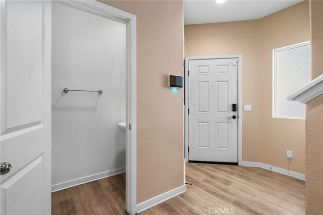 foyer entrance with wood finished floors and baseboards