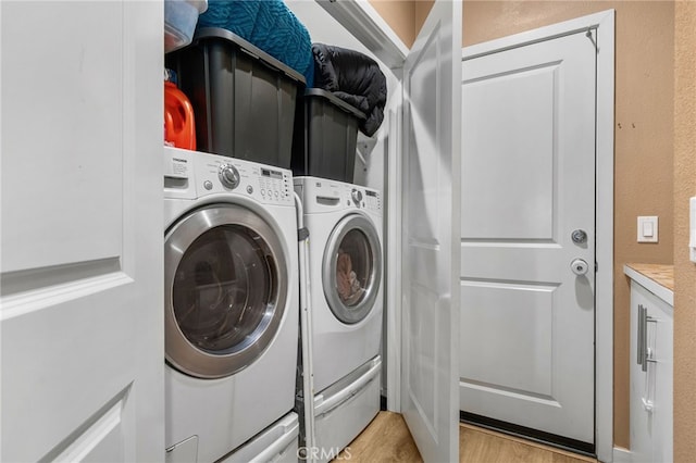 clothes washing area featuring laundry area, light wood-type flooring, and washing machine and clothes dryer