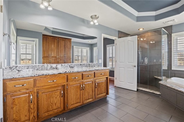 full bath with vanity, visible vents, a tray ceiling, a stall shower, and crown molding