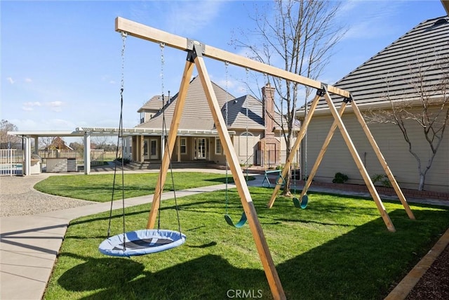 view of playground with a lawn, a pergola, and a patio