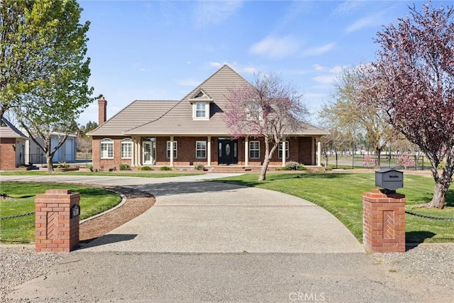 view of front of home featuring brick siding, driveway, a porch, and a front yard