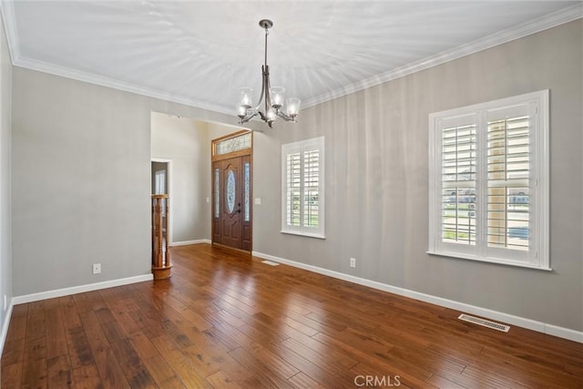 foyer entrance with visible vents, hardwood / wood-style flooring, baseboards, and ornamental molding