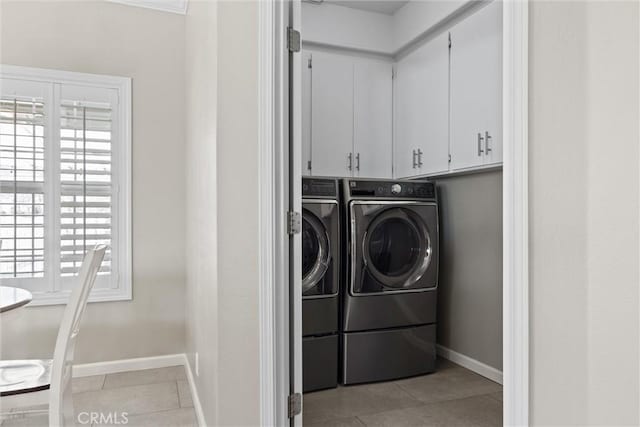 clothes washing area with light tile patterned floors, cabinet space, independent washer and dryer, and baseboards