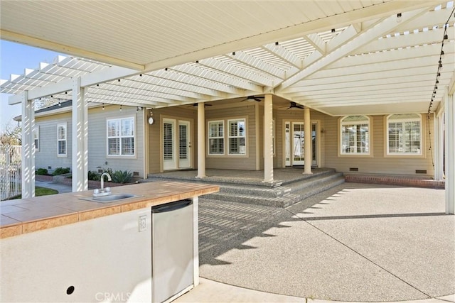 view of patio / terrace with ceiling fan, a pergola, and a sink