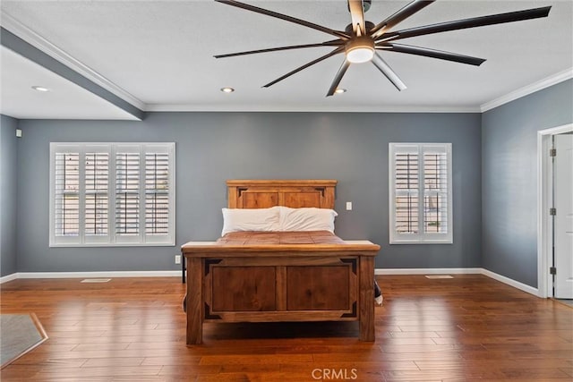 bedroom with crown molding, wood finished floors, and baseboards