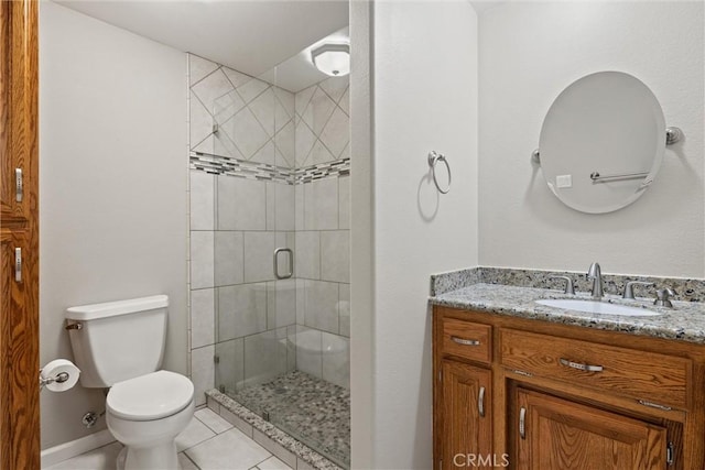 full bath featuring tile patterned floors, toilet, a shower stall, baseboards, and vanity