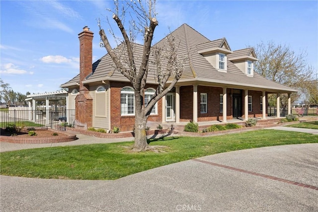 view of front of house with a front lawn, fence, brick siding, and a chimney