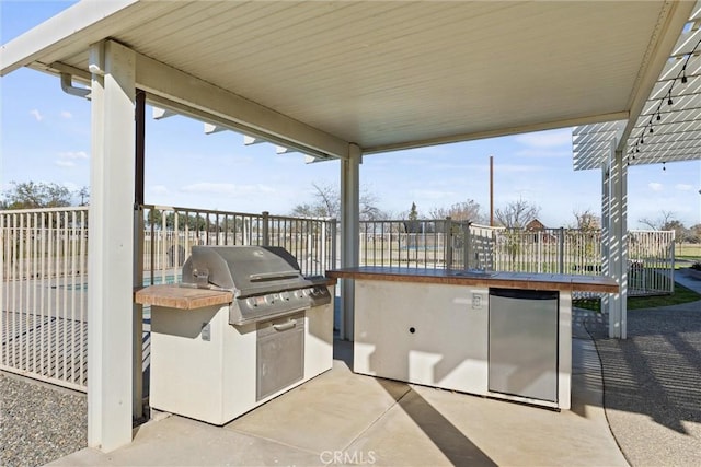 view of patio / terrace with area for grilling, an outdoor kitchen, and fence