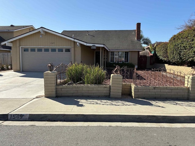 view of front of property featuring fence, a garage, driveway, and a chimney