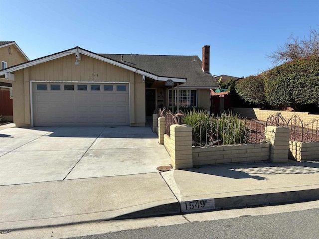 view of front of property featuring fence, driveway, roof with shingles, a chimney, and a garage