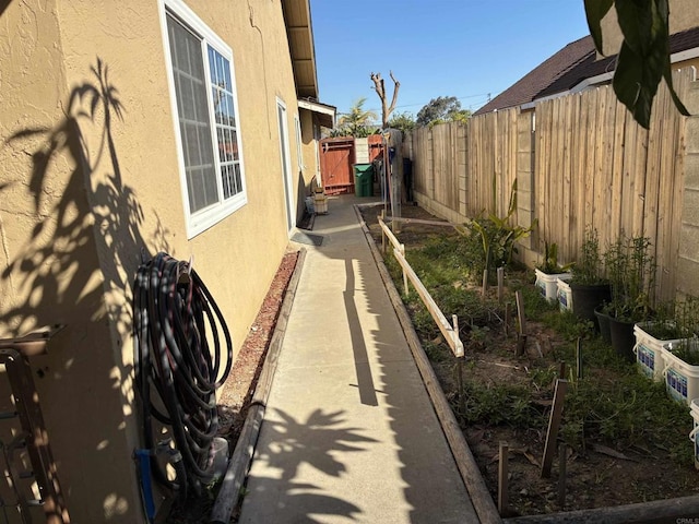 view of home's exterior featuring a garden, fence, and stucco siding