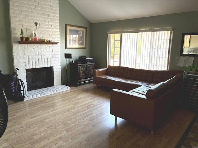 living area with lofted ceiling, wood finished floors, and a fireplace