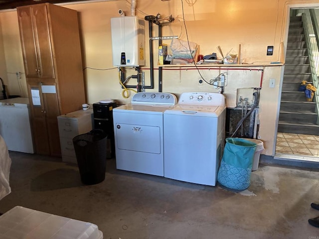 laundry area featuring tankless water heater, washing machine and dryer, and laundry area