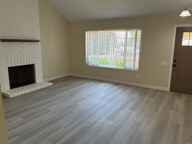 1549 Grand Teton Ct, Chula Vista, CA 91911 - unfurnished living room with wood finished floors, a brick fireplace, and vaulted ceiling